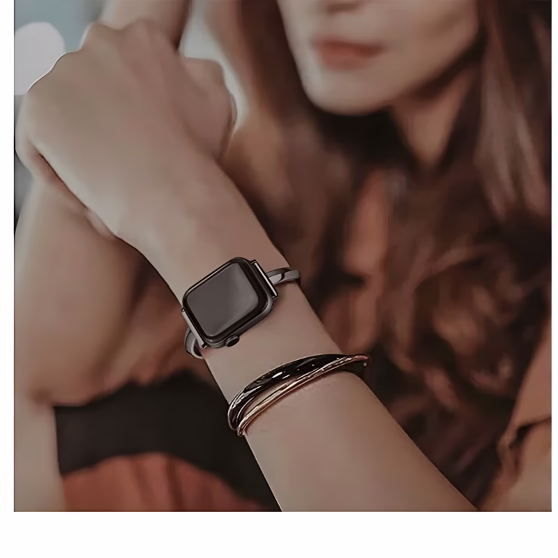 Bracelet Apple Watch EzStrap en métal lisse, style élégant avec demi-jonc et chaînette, porté au poignet d’une femme aux cheveux longs, en plan rapproché.