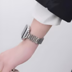 Bracelet Apple Watch EzStrap en métal inoxydable, style élégant à maillons lisses, porté au poignet d’une personne en chemise blanche.