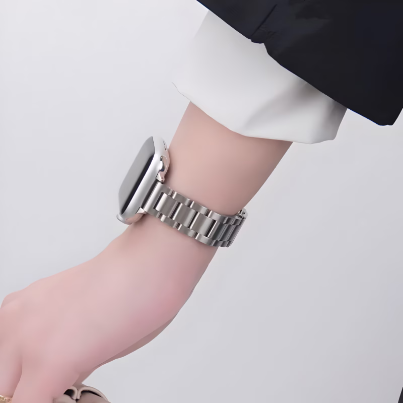 Bracelet Apple Watch EzStrap en métal inoxydable, style élégant à maillons lisses, porté au poignet d’une personne en chemise blanche.