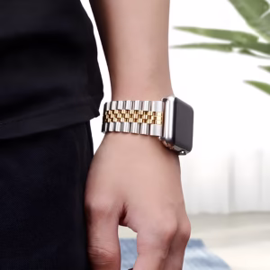 Bracelet Apple Watch EzStrap en acier inoxydable poli-brossé, style luxe Jubilé à maillons lisses bicolores argent et or, porté au poignet d’un homme en tenue décontractée.