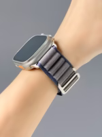 Bracelet Apple Watch EzStrap en métal au style sport avec finition texturée, porté au poignet d’une personne sur fond gris.