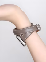 Bracelet Apple Watch EzStrap en cuir lisse marron au style élégant, à enroulement double, porté au poignet d’une personne sur fond neutre.