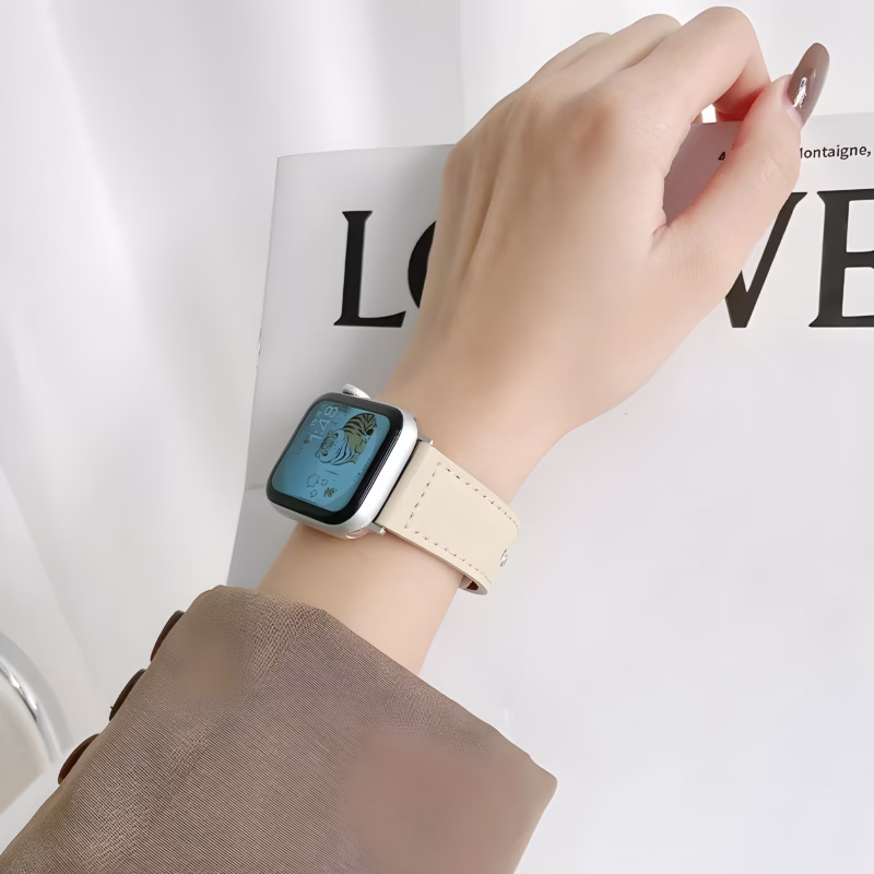Bracelet Apple Watch EzStrap en cuir lisse beige avec couture apparente, de style élégant, porté au poignet d’une femme en veste beige.