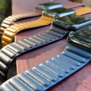 Bracelet Apple Watch EzStrap en cuir texturé de style élégant, posé en extérieur sur une surface en bois avec plusieurs montres alignées.