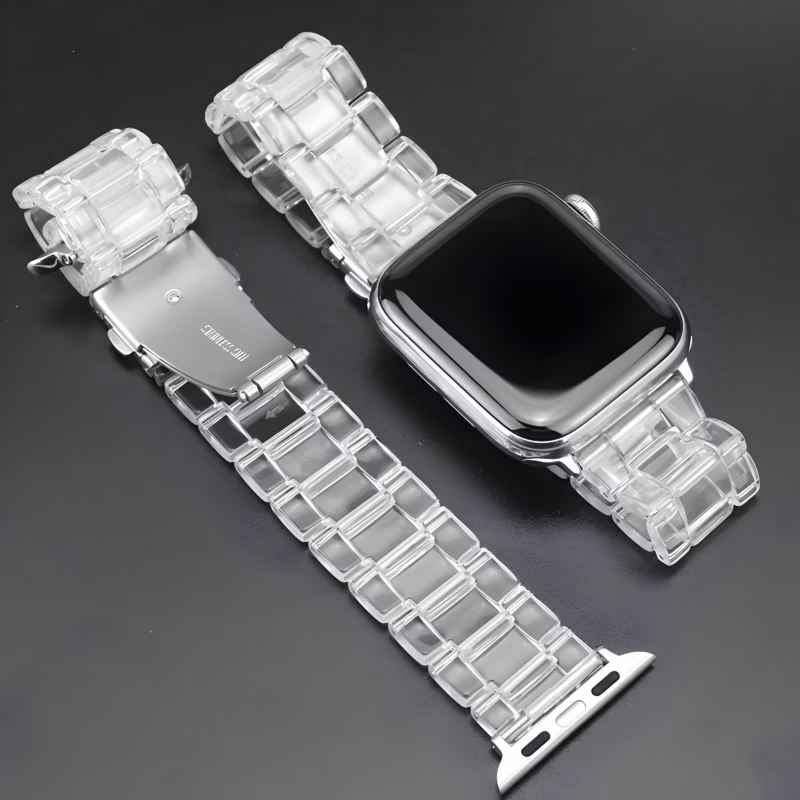 Bracelet Apple Watch EzStrap en plastique transparent à maillons articulés, au style élégant et à la finition lisse, présenté à plat sur une surface noire.