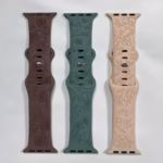 Bracelet Apple Watch EzStrap en silicone gravé à motif floral, décliné en trois coloris (marron, vert et beige), posé à plat sur un fond blanc.