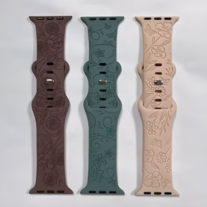 Bracelet Apple Watch EzStrap en silicone gravé à motif floral, décliné en trois coloris (marron, vert et beige), posé à plat sur un fond blanc.