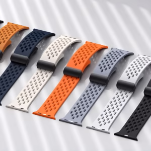 Bracelet Apple Watch EzStrap en silicone perforé de style sport, décliné en plusieurs coloris, présenté à plat sur une surface claire avec des ombres de lumière.