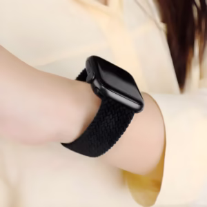 Bracelet Apple Watch EzStrap en nylon texturé noir, style sport, porté au poignet d’une femme en chemise claire.