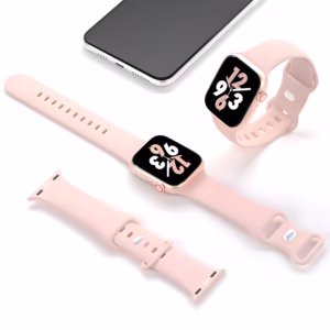 Bracelet Apple Watch EzStrap en silicone lisse rose pâle, style sport, présenté posé à plat et autour d’une montre connectée, avec un smartphone en arrière-plan.
