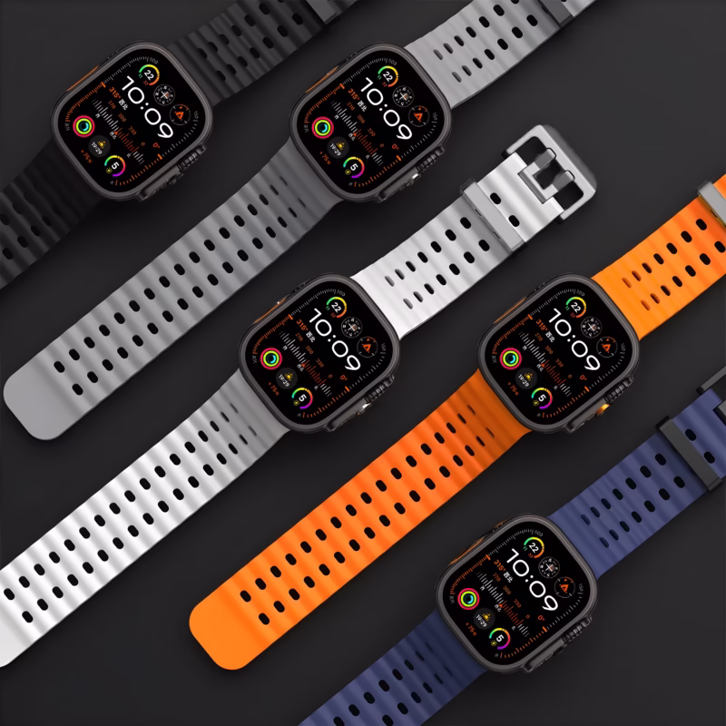Bracelet Apple Watch EzStrap en silicone perforé, style sport, décliné en plusieurs coloris dont noir, blanc, orange et bleu, présenté à plat sur fond noir.
