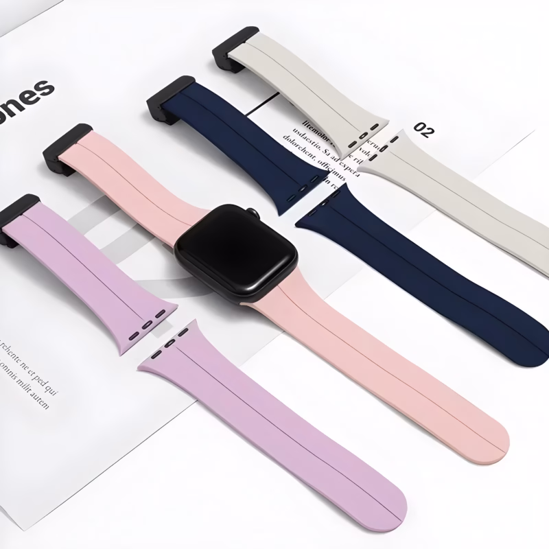 Bracelet Apple Watch EzStrap en silicone lisse, style sport, présenté en plusieurs coloris posés à plat sur un magazine.