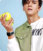 Bracelet Apple Watch EzStrap en silicone sport perforé noir et vert, porté au poignet d’un homme tenant des balles de tennis.