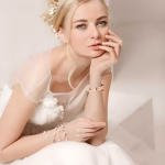 Bracelet Apple Watch EzStrap en métal acier inoxydable, style élégant avec design de cœurs entrelacés scintillants, porté au poignet d’une femme en robe de mariée.