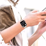Bracelet Apple Watch EzStrap en métal inoxydable à maillage fin Milanais, de style élégant et à finition lisse, porté au poignet d’une femme utilisant son téléphone.