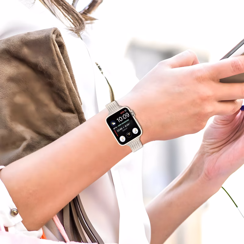 Bracelet Apple Watch EzStrap en métal inoxydable à maillage fin Milanais, de style élégant et à finition lisse, porté au poignet d’une femme utilisant son téléphone.