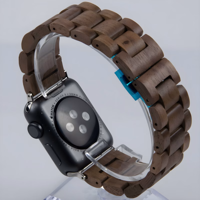 Bracelet Apple Watch EzStrap en bois naturel à maillons articulés, au style élégant et artisanal, présenté en gros plan sur support transparent.