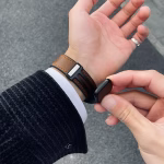 Bracelet Apple Watch EzStrap en cuir véritable grainé avec doublure en silicone, style premium, porté au poignet d’un homme en veste texturée sur fond de trottoir urbain.
