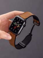 Bracelet Apple Watch EzStrap en cuir véritable grainé avec intérieur en silicone, au style élégant, tenu à la main sur fond sombre.