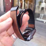 Bracelet Apple Watch EzStrap en cuir véritable grainé avec intérieur en silicone, de style élégant, tenu en gros plan dans la main d’un homme devant une vitrine de magasin.