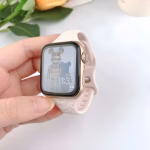Bracelet Apple Watch EzStrap en silicone texturé coloris crème, style sport avec motif léopard en relief, tenu en gros plan par une main sur fond clair.