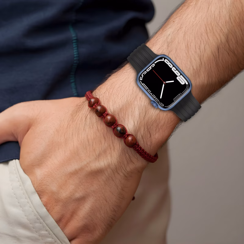 Bracelet Apple Watch EzStrap en silicone texturé noir, style sport avec rainures, porté au poignet d’un homme vêtu d’un t-shirt bleu.