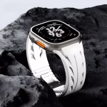 Bracelet Apple Watch EzStrap en silicone blanc, style sport avec fentes dynamisées texturées, présenté en gros plan sur un fond de roche sombre.
