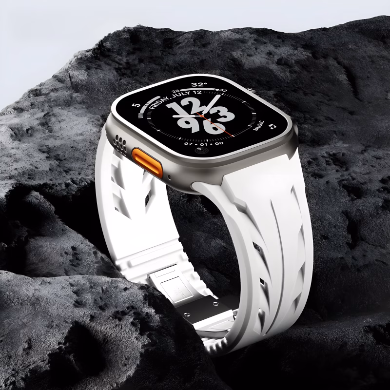 Bracelet Apple Watch EzStrap en silicone blanc, style sport avec fentes dynamisées texturées, présenté en gros plan sur un fond de roche sombre.