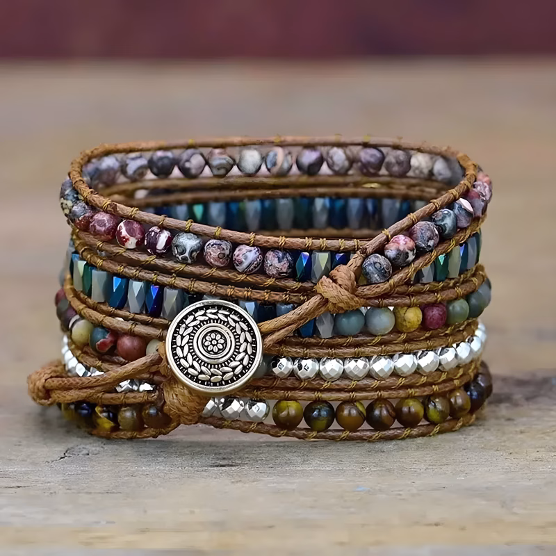 Bracelet Apple Watch EzStrap multi-couches en cuir tressé avec perles colorées et bouton gravé en métal, présenté en gros plan sur une surface en bois.