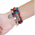 Bracelet Apple Watch EzStrap multirangs en métal et perles ornementées, de style artisanal et texturé, porté au poignet d'une personne sur fond blanc.
