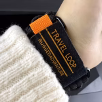 Bracelet Apple Watch EzStrap en nylon tressé de style sport avec empiècements métalliques, au design texturé inspiré de la paracorde, porté au poignet d’une personne en pull blanc.