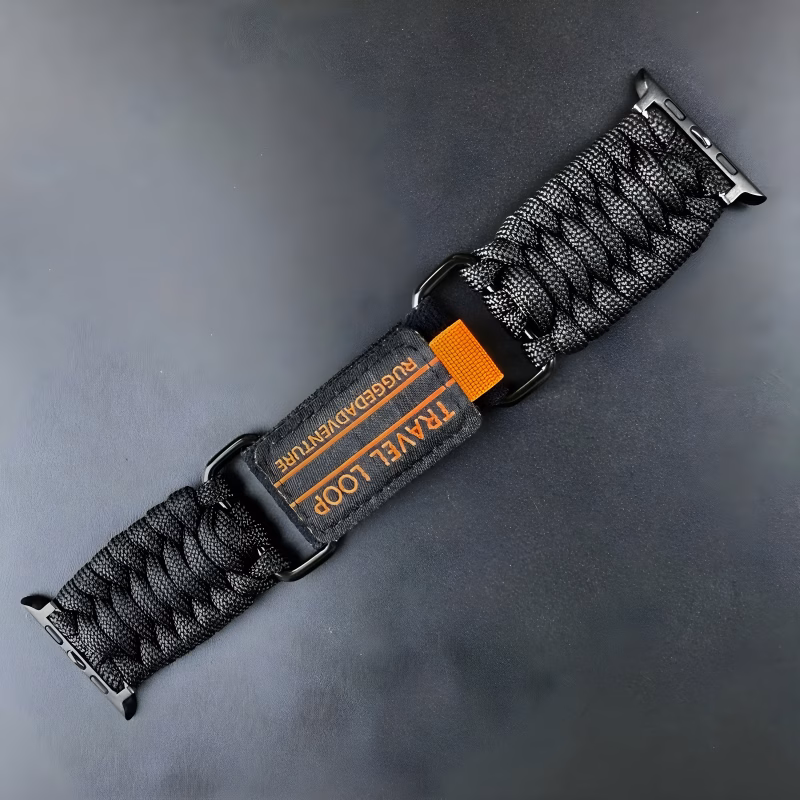 Bracelet Apple Watch EzStrap en nylon tressé avec éléments métalliques, au style sport texturé, photographié en gros plan sur fond noir.