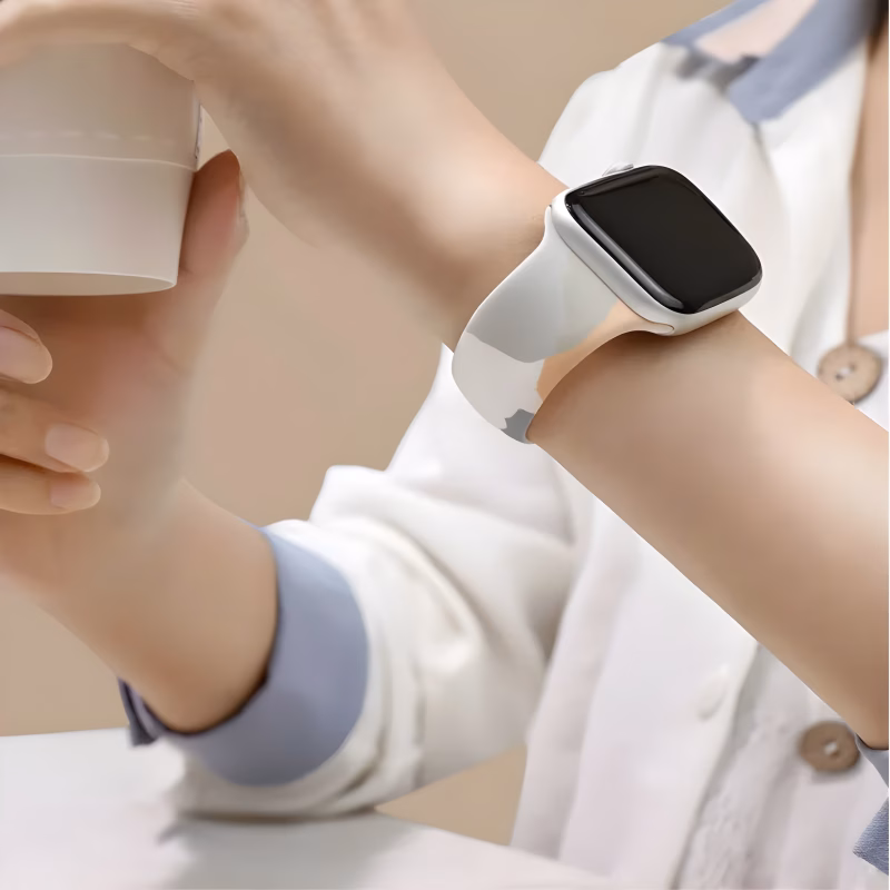 Bracelet Apple Watch EzStrap en silicone mat à design artistique abstrait, porté au poignet d’une personne tenant un gobelet, vêtue d’une chemise blanche.