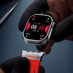 Bracelet Apple Watch EzStrap en métal au design sport perforé rouge, tenu en gros plan par une personne portant des gants noirs.