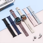 Bracelets Apple Watch EzStrap en silicone au design sport ondulé, présentés côte à côte sur une surface pastel avec deux montres connectées et des écouteurs blancs.