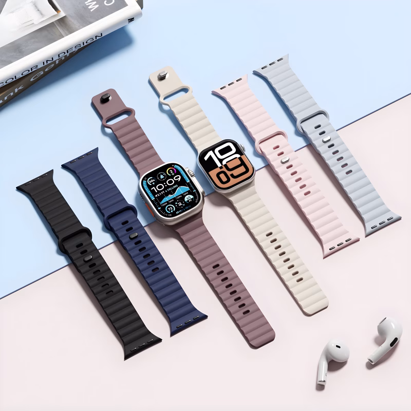 Bracelets Apple Watch EzStrap en silicone au design sport ondulé, présentés côte à côte sur une surface pastel avec deux montres connectées et des écouteurs blancs.