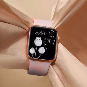 Bracelet Apple Watch EzStrap en silicone rose à motif floral gravé, présenté en gros plan sur un tissu beige noué élégamment.