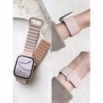 Bracelet Apple Watch EzStrap en silicone rose pâle au design ondulé, style sport, porté au poignet d’une personne et présenté en gros plan sur une surface claire.
