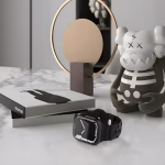 Bracelet Apple Watch EzStrap en silicone noir mat, style sport avec design perforé, posé sur une table en marbre à côté de livres et d'une figurine décorative.