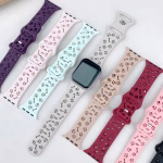 Bracelet Apple Watch EzStrap en silicone souple, style sport, avec motif perforé de pattes d’animaux et d’os, présenté à plat sur une surface blanche aux côtés de plusieurs coloris.