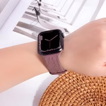 Bracelet Apple Watch EzStrap en silicone texturé mauve, style élégant avec motif floral en relief 3D, porté au poignet d’une femme près d’un décor en rotin.