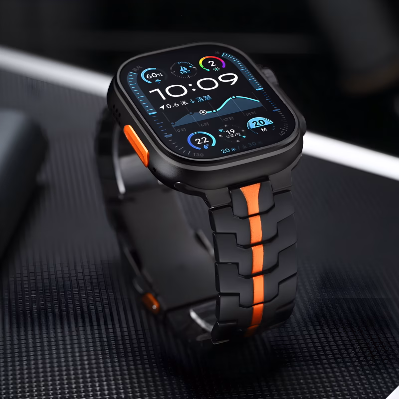 Bracelet Apple Watch EzStrap en métal noir au style sportif, avec une bande orange centrale, présenté en gros plan sur une surface texturée noire.